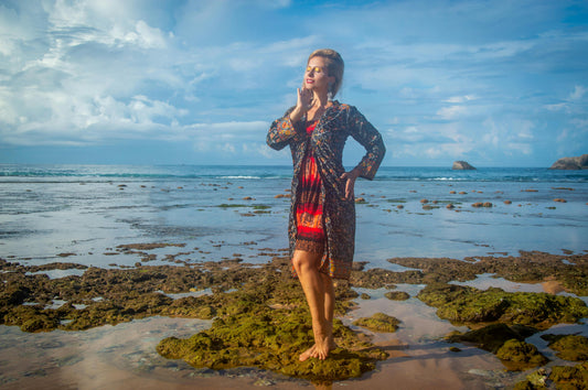 Woman wearing a floral cotton voile dress on an Australian beach, styled for a warm summer day